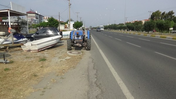 Balıkesir Edremit'te meydana gelen kazada bölünmüş yolda bir otomobilin arkadan çarptığı traktör yoldan çıkarak iş yerine daldı. O sırada iş yerinde köpeği ile bulunan çocuk, traktörün altında kalmaktan saniyelerle kurtuldu.