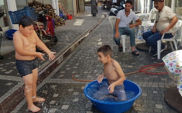 Edremit ilçesindeki esnaflar, yaz sıcaklarını hafifletmek ve çocuklarını serinletmek amacıyla yaratıcı bir çözümü hayata geçirdi. Sokaklara yerleştirdikleri leğenlerle çocuklar, serinlemek için suyun keyfini çıkarırken, bu anlar renkli ve neşeli görüntülere sahne oldu.